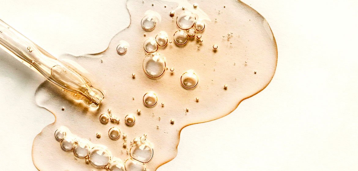 Pipette und gelbe Flüssigkeit mit Retinol auf hellgelbem Hintergrund